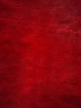 Dark red matte background of suede fabric, closeup. Vertical red velvet backg Stockfoto's