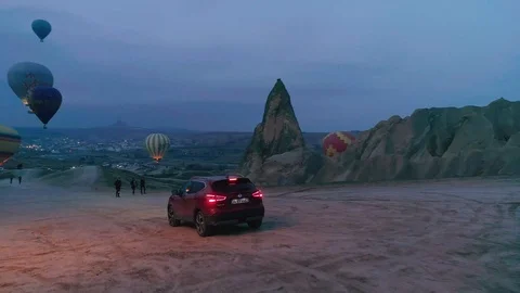 Dark red SUV flying through hot air baloons early in the morning, dawn, jb01 Stock Footage 105022854
