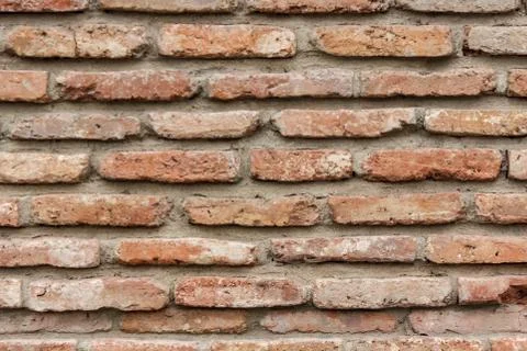 A dark red texture from an old brick wall. A destructive destruction of a bri Stock Photos