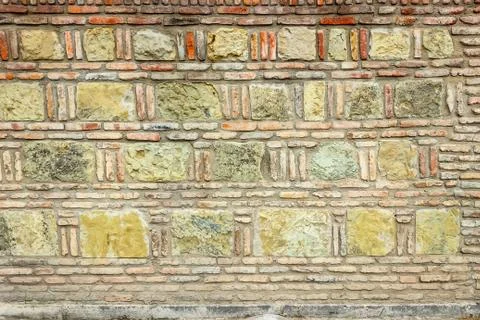 A dark red texture from an old brick wall. A destructive destruction of a bri Stock Photos