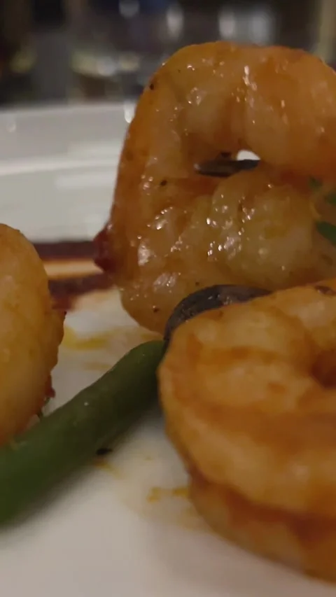 In a dark restaurant, stabbing shrimp with a fork, Mexican food Eating fried Stock Footage 302803118