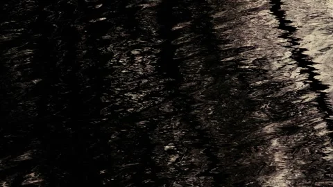 Dark rippled water surface with distorted black and white reflections, creating 库存影片 334936746