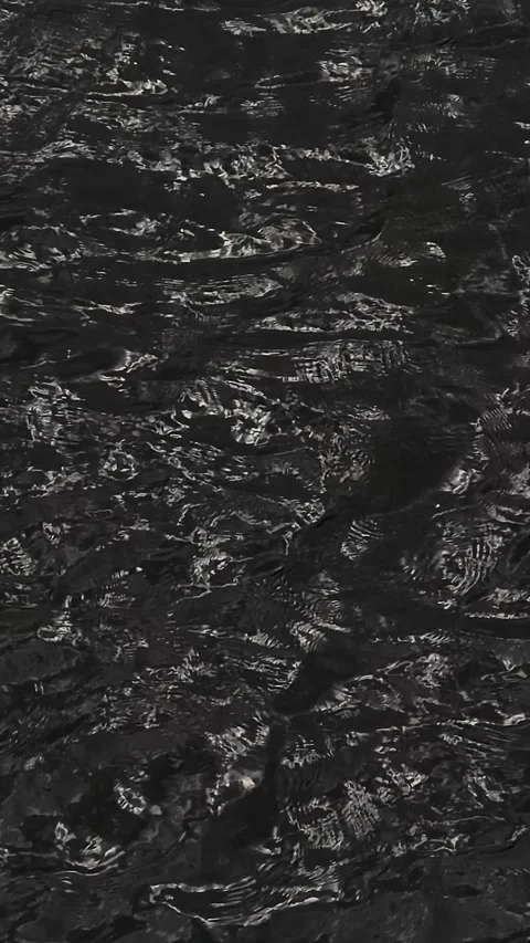 Dark rippling water surface with light reflections and mysterious black textu Stock Footage 327974828