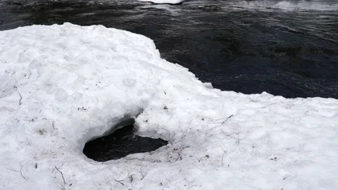 A dark river under a snow cover in winter or early spring Stock Footage 203975886