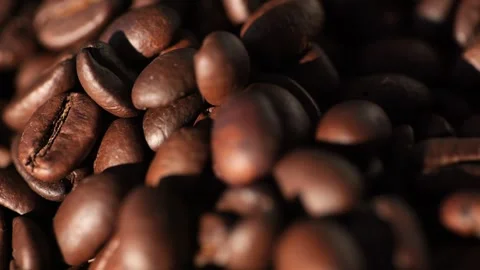 Dark roasted coffee beans falling, showcasing vibrant texture and aroma of Stock Footage 295109868