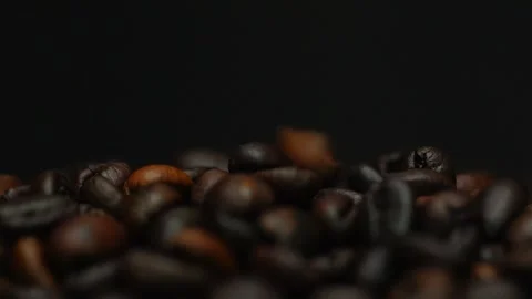 Dark roasted coffee beans falling on a black background. Slow motion Stock Footage 300243195