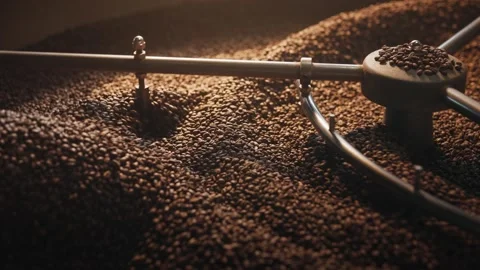 Dark roasted coffee beans mixing in large cooling drum under rotating arms Stock Footage 315749753