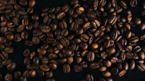 Dark roasted coffee beans moving on a black background Stock Footage 340142981