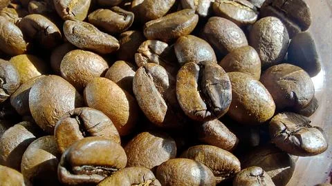 Dark roasted coffee beans ready for brewing in a rustic setting Stock Photos