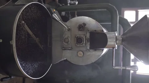 Dark roasted coffee grains being mixed inside of a roaster machine cooling tray Stock Footage 219592492
