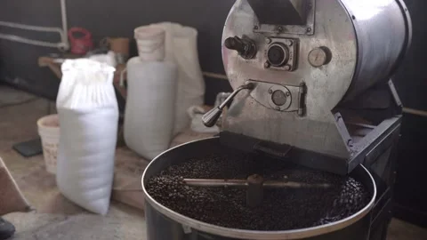 Dark roasted coffee grains being mixed inside of a roaster machine cooling tray Stock Footage 219592567