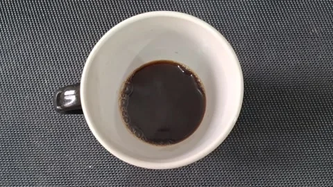Dark roasted coffee inside white ceramic mug motion video footage Video stock 339249039