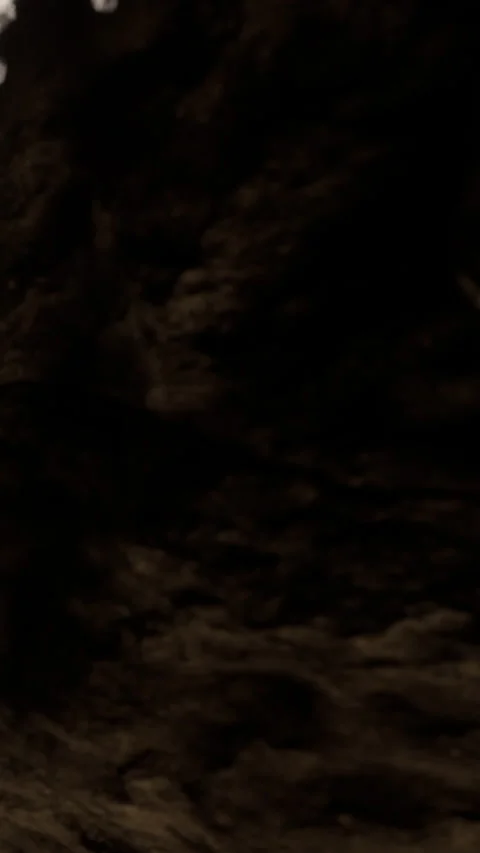 Dark rock formation with light casting shadows in a natural setting Stock Footage 341266266
