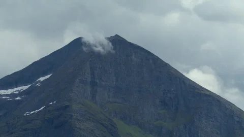 Dark Rock Peak with Small Cloud Drifting Over Summit in Norway Stock Footage 340321680