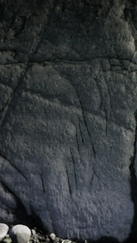 Dark rock surface with cracks and lines in a natural setting Stock Footage 334882270