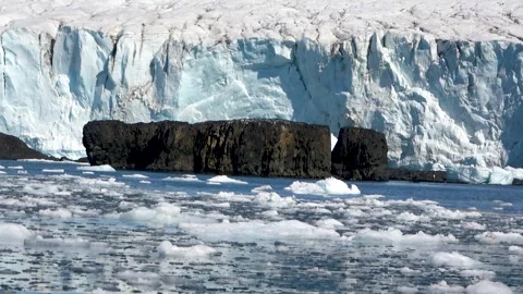 Dark rocks in front of glacier ice Antarctica landscape, 4K Stock Footage 332374336