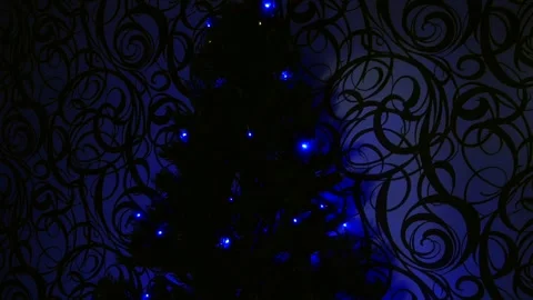 In a dark room, a Christmas tree blinks and shines with yellow-blue lights. Vídeos de archivo 259699680