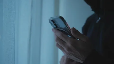 Dark room close up on person's hand holding and using smartphone at night Stock Footage 341837137