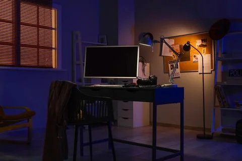 Dark room detective office with computer monitor, camera, and investigation b Foto stock