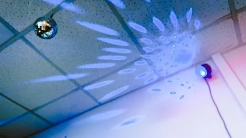 Dark room with disco lights background. Disco ball and stroboscope on ceiling Stock Photos