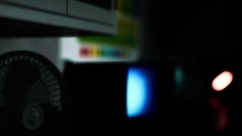 Dark room with electronic devices and a fan in the background Stock Footage 344965045