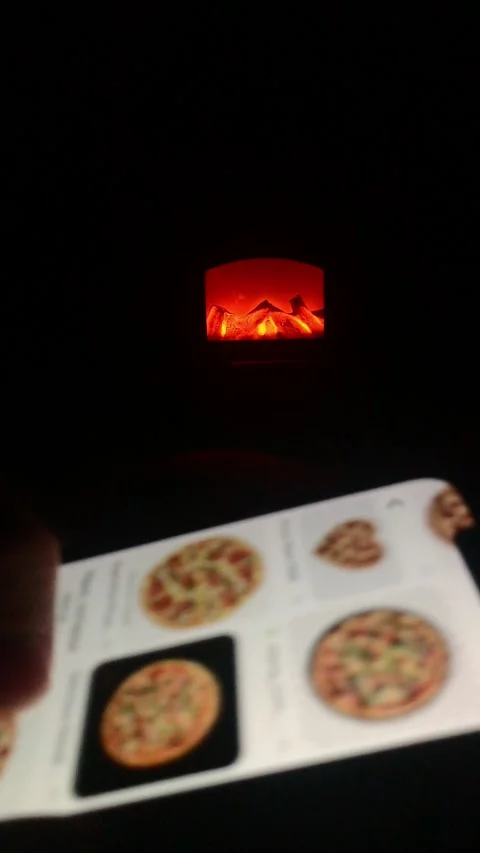 In a dark room, in front of a burning hearth, a man on a smartphone screen .. Stock Footage 306316007