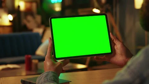 In dark room hands man holding scrolling and tapping on tablet computer with Stock Footage 238745846