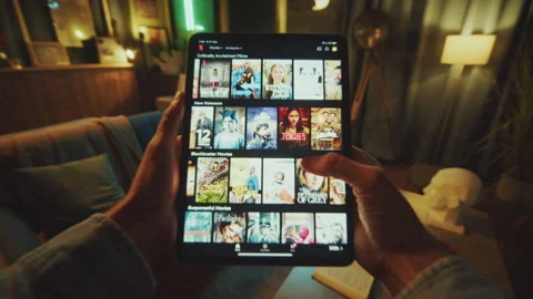 In dark room hands man lying sitting on the sofa at home. Scrolling tablet Stock Footage 238744112