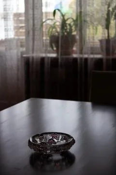 A dark room on the table is an empty ashtray Stock Photos