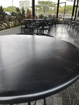 Dark Round Table Surface in Outdoor Cafe Setting Stock Photos
