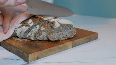 Dark rye wheat bread cutting on wood block 動画素材 223691008