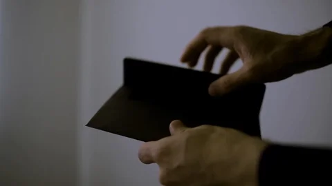 Dark scene - Man opens an envelope with Israeli money inside then counts it Stock Footage 108586295
