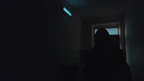 Dark scene, slow motion tracking shot of adult girl walks along dark corridor Stock-Footage 122408502