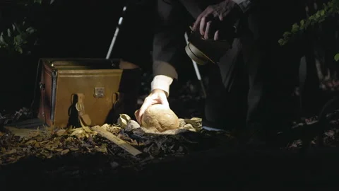 Dark scene of a victorian detective looking a skull from a  crime Vidéo 317323402