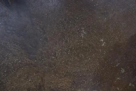 Dark scuffed surface of a stone slab. Rough texture of brown stone or rock Stock Photos