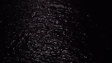 Dark sea and ocean surface with rippling waves illuminated by full moonlight at Vidéo 318458066