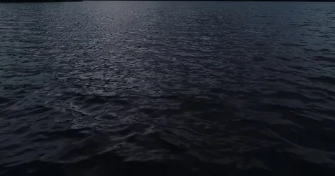 Dark sea water camera tilting up reviling beautiful dark horizon with stormcloud Stock Footage 79341165
