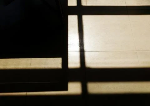 Dark shadow of door or window on tile floor background. Abstract or Art Stock Photos