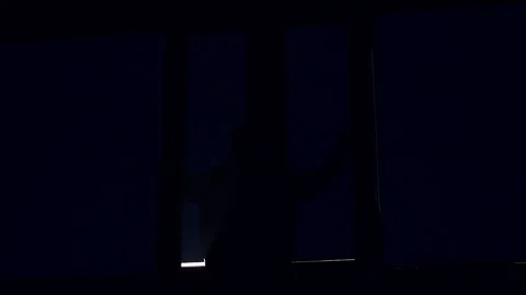 In dark shot of silhouette man open striped blinds on a window i dirty window Stock Footage 105203396