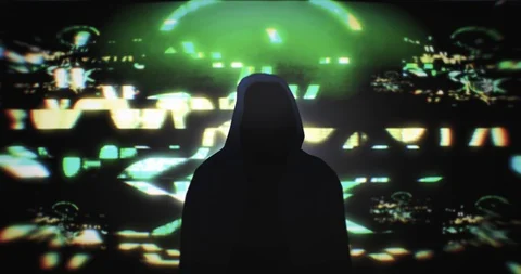 Dark silhouette of hooded hacker in front of a glitch screen with a skull Stock Footage 129383531