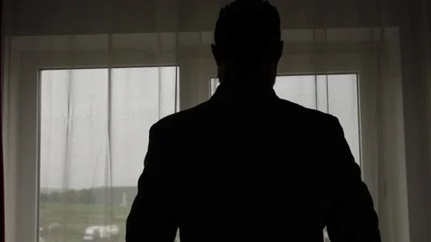 Dark silhouette of man dressing with a jacket for weading or event Stock Footage 93079141