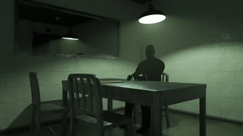 Dark silhouette of a man sitting in empty interrogation room. Stock Footage 89586177