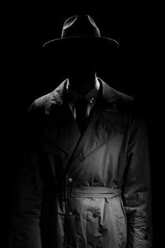 A dark silhouette of a man without a face in a coat and hat in the noir style Stock Photos