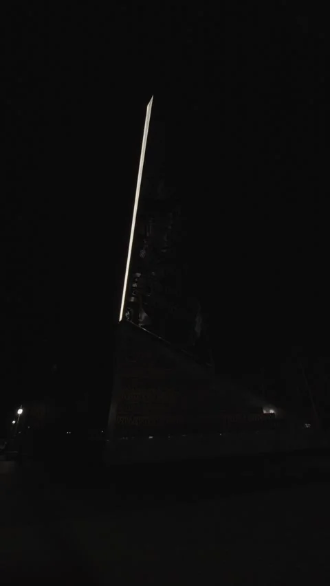 Dark silhouette of tall monument with bright vertical light line Stock Footage 333009268