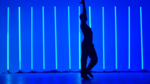 Dark silhouette of a young man dancing bylane dances. A professional ballroom Stock Footage 146085692
