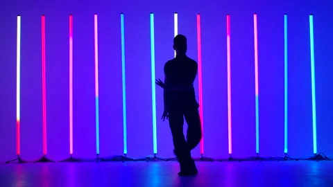 Dark silhouette of a young man dancing rumba in the studio against the Stock Footage 146085896