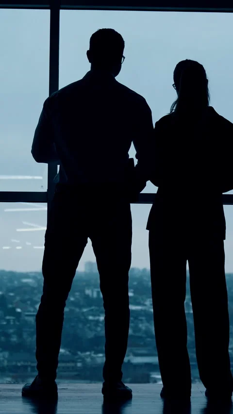 Dark silhouettes of a couple standing looking at the window. Stock Footage 320886620