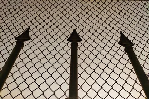 Dark silhouettes of forged elements in the form of sharp peaks against the .. Stock Photos