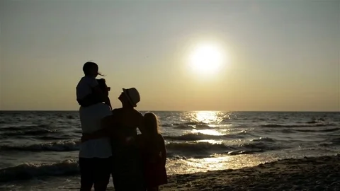 Dark Silhouettes of Parents with Two Daughters Looking at Sunset near the Sea. Stock Footage 82233380