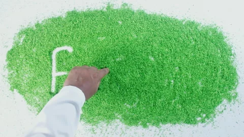 Dark skin man's hand writing in green sand words Fennel Stock Footage 248644043
